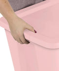 Person holding the edge of a Pink 18 Gallon Storage Bin With Secure Snap On Lid Heavy Duty Stackable Plastic Tote.