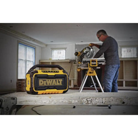 20V Max Bluetooth Jobsite Speaker with 100 ft range on a workbench, visible rugged build and controls