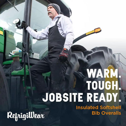 Extreme Cold Insulated Bib Overalls For Men And Women, person standing with tractor in heavy duty work gear, black and lime, XXL.