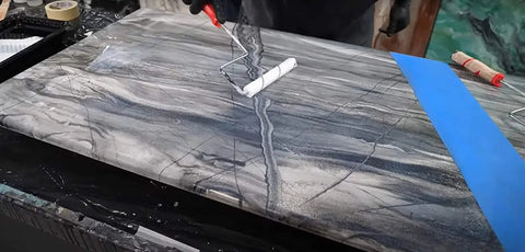 Two Pack Pro Grade Quarter Inch Microfiber Roller Sleeves For Epoxy Resin And Painting No Shed Nap For Woodworking And Home Improvement Dry Or Wet Application Of Primer Undercoat And Enamels being used on a gray marble surface