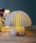 Walnut Finish Mushroom Lamp With White Striped Glass Retro Mid Century Table Light illuminating a living room setting