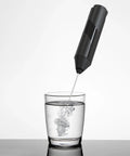 Hardcore Milk Frother For Coffee Fast Handheld Drink Mixer with Stainless Steel Whisk creating foam in a glass of water