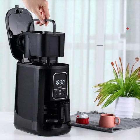 Compact Automatic Freshly Ground Coffee Brewer With Onboard Bean Grinder And Programmed Cup Settings, black unit with grinder visible.