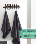 Hella Tough Cast Iron Wall Hook Rack With Seven Cute Cat Designs For Coats Keys And Hats with two gray towels hanging.