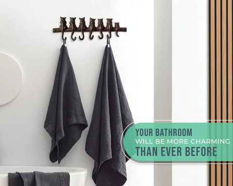 Hella Tough Cast Iron Wall Hook Rack With Seven Cute Cat Designs For Coats Keys And Hats with two gray towels hanging.