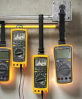 Magnetic Multimeter Hanging Kit With Straps Clips And A Magnet Hanger securing three Fluke meters in a testing setup