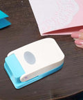 Dope Tiny Paper Punch Hole Puncher For Scrapbooking And Photo Albums, Oval Shape, Acrylic And Metal Cutter on a table with hands