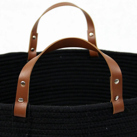 Close-up of XXXLarge Cotton Rope Storage Basket With Leather Handles For Living Room Go To Organizer For Blankets Towels And Pillows Black 20x20x13 Inches Durable Cotton Rope Craft With Leather Accents For Laundry Or Decorative Storage, featuring brown leather handles on black woven material.