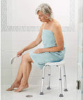 Person sitting on Compact Shower Stool With Adjustable Height, Sturdy Aluminum Bath Seat For Narrow Tubs, Rock Solid Stability.