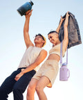 Half Gallon Insulated Water Jug With Comfy Grip Handle Keeps Your Drinks Ice Cold All Day Long No Fuss Carry Design, stylish duo celebrating outdoors.