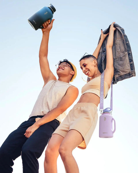 Half Gallon Insulated Water Jug With Comfy Grip Handle Keeps Your Drinks Ice Cold All Day Long No Fuss Carry Design, stylish duo celebrating outdoors.