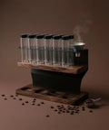 Heavy Hitter Coffee Bean Storage Rack With Twelve Clear Glass Bottles And Solid Wood Base keeping coffee organized on countertop.