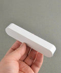 Hand holding a Matte White Kitchen Cabinet Handle from Pack Of 5 Cup Pulls, showing front view, 3.8 inch center to center, 4.7 inch long.