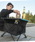 Person using Foldable Camping Table With Storage Bag Kit For Picnic And Barbecue Quick Assembly Portable Beach Table outdoors.