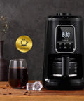 Compact Automatic Freshly Ground Coffee Brewer With Onboard Bean Grinder And Programmed Cup Settings on kitchen counter with coffee glass.