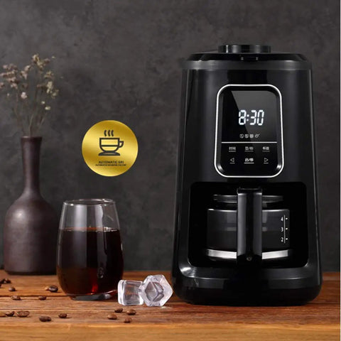 Compact Automatic Freshly Ground Coffee Brewer With Onboard Bean Grinder And Programmed Cup Settings on kitchen counter with coffee glass.