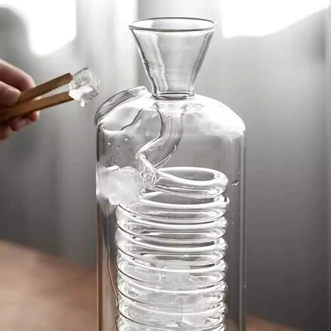 Top Shelf Cold Brew Drip Tower Coffee Maker With Glass Spiral Cooling Tube And Adjustable Faucet Slow Drip System adding ice.