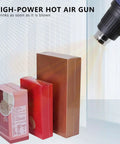 Pro Heat Shrink Wrap Machine And Sealer For Plastic Film in use, hot air gun shrinking plastic around packaged boxes.