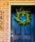 Wooden address plaque with black numbers 3406 mounted on brick wall beside a blue front door.