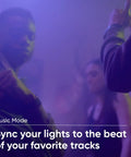 People dancing in dim light with Smart LED Light Strip Pro 32.8ft WiFi RGB Strip With 16 Million Colors in music sync mode.