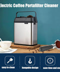 Electric Automatic Coffee Grounds Cleaner For Espresso Portafilter Handles With Built In Brush And Powder Wiper Tool No Sweat Cleanup And Smooth Operator Design For Real Home Baristas Silver on wooden table with cup and coffee beans.