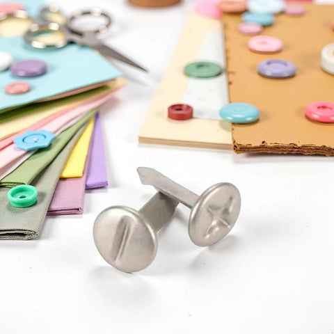 Top Notch 100 Piece Silver Phillips Head Screw Brads For Scrapbooking And Paper Crafting shown with cardstock and buttons.
