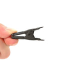 Hand holding a 2-inch spring clamp, part of All Black 100 Pack 2 Inch Spring Metal Clamps For Woodworking Diy Projects Durable Nickel Plated Steel Clips Ideal For Carpentry Home Decor And Industrial Use, showcasing nickel-plated steel material.