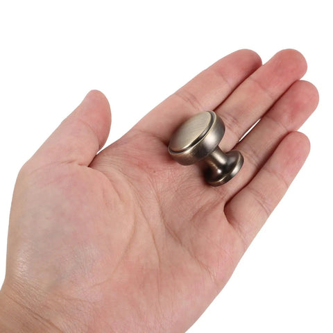 4 Pack Brushed Zinc Alloy Cabinet Pulls Single Hole Drawer Handles in a hand, showcasing solid build and design.