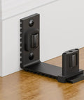 Adjustable Sliding Barn Door Floor Guide With Rock Solid Heavy Duty Metal Base And Double Nylon Quiet Rollers For A Smooth As Butter Glide On Any Interior Door Frame In Sleek Black close-up view mounted on floor.