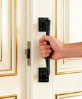 Hand holding Two Pack Heavy Duty Cast Iron Barn Door Handles Nine And Three Quarters Inches Rustic Gate Pulls against white door