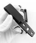 Gloved hand holding Rugged Durable Tactical Holster Clips And Knife Scabbard Kit for back waist gear with adjustable fit.