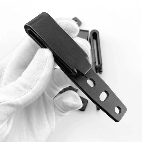 Gloved hand holding Rugged Durable Tactical Holster Clips And Knife Scabbard Kit for back waist gear with adjustable fit.