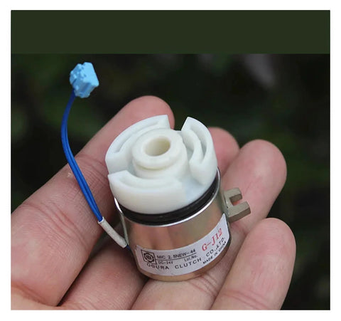 Close-up front view of a small DC24V electromagnetic clutch with white plastic rotor, metal housing, and blue wire