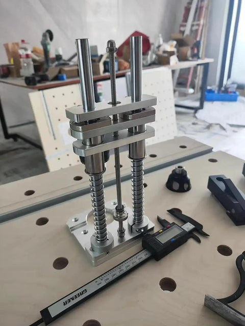 Compact Drill Press Stand With Vertical Drill Guide for Hand Drills, sturdy aluminum, on workshop bench for woodworking.