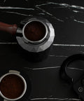Coffee Portafilter Holder And Espresso Tamper Stand with 58mm portafilter, on a black marble countertop