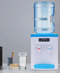 Compact 110V 550W Portable Countertop Water Dispenser With Hot And Cold Water Tiny Desk Side Hydration Station on tabletop with glass