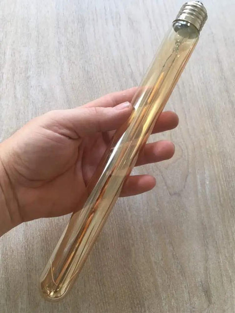 Hand holding Retro Tubular LED Filament Bulb 6W Dimmable Edison Style Amber Glass Warm White 2300K 40W Equivalent