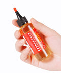 Hand holding a 60ml bottle of door hinge lubricant penetrating oil for no more squeaks and rust prevention, multi purpose lubricant for fans.
