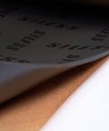 Close-up of Badass 4mm Car Sound Deadening Heat Insulation Mat showing layered adhesive and closed cell foam material.