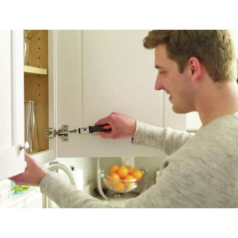 Man using a tool from the 12V Max Drill And Home Tool Kit 60 Piece Set with Compact Lithium Ion Drill for cabinet repair.