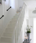 Industrial Pipe Door Pull Handle 12 Inch Black Rustic Grab Bar mounted on white staircase wall.