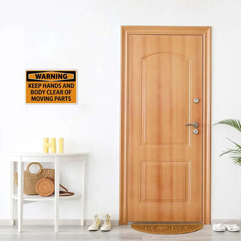 Warning Keep Hands And Body Clear Of Moving Parts Tin Sign on wall above wooden door in home entryway