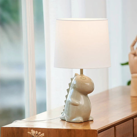 Tommy Dinosaur 16 Inch Ceramic Table Lamp In Green With White Cotton Shade on wooden dresser in kids room