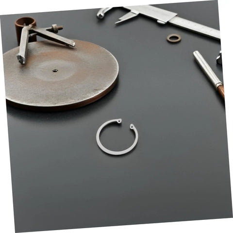 Five Piece Stainless Steel Internal C Clip Snap Ring Set for Grooved Shafts and Studs displayed with tools on a table.