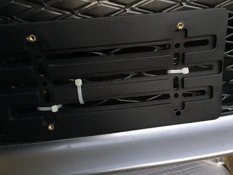 Mercedes-Benz Front Bumper License Plate Holder Kit Bolt-On Relocator Mount installed on flat bumper, hardware visible.