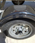 Close-up of a trailer wheel with Trailer Hub Cap Protector In Stainless Steel Bearing Buddies, 1.98 Inch Diameter installed, outdoors