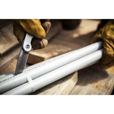3 1/4 Inch Drop Point Pocket Knife With Aluminum Handle cutting pipes, showcasing D2 Steel Blade and smooth ball-bearing deployment
