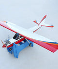 Blue Double Slot RC Aircraft Foam Stand holding a red and white RC plane. Portable Detachable Aircraft Bracket shown in use.