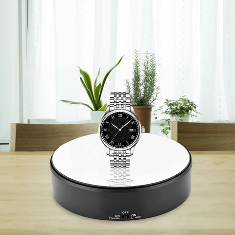 Mirror Surface Motorized Turntable Display Stand With 360 Degree Rotary Motion And Adjustable Speed showcasing a silver watch on a table.