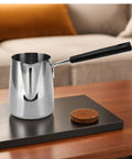 Stainless Steel 304 Milk Frothing Pitcher 350ml Rustproof Barista Grade Pouring Jug With Hanging Hole on wood table